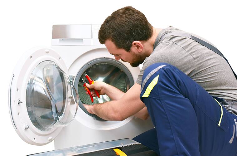 Technicien qui répare un sèche linge